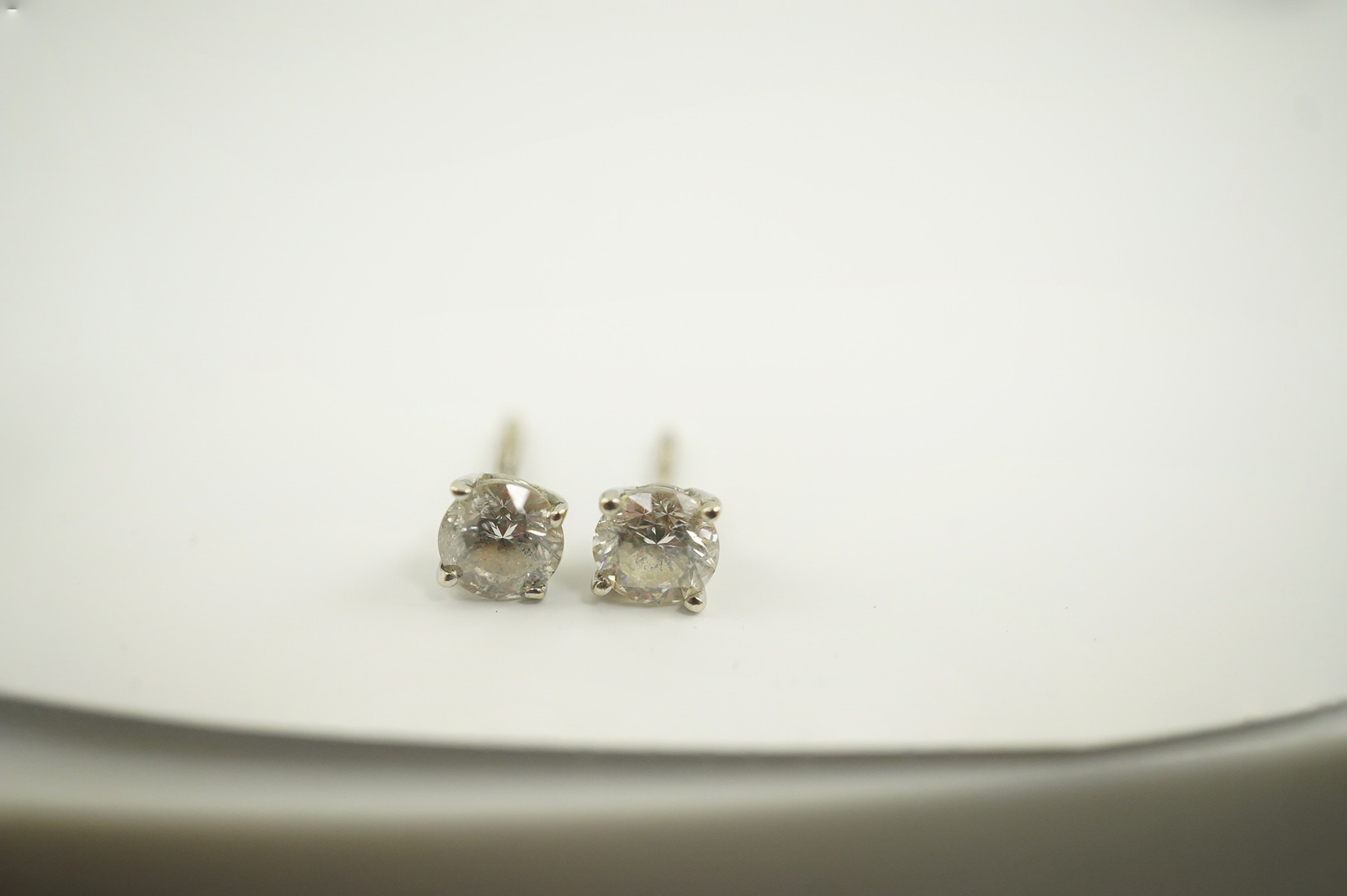 A pair of 14k white gold and solitaire diamond set ear studs